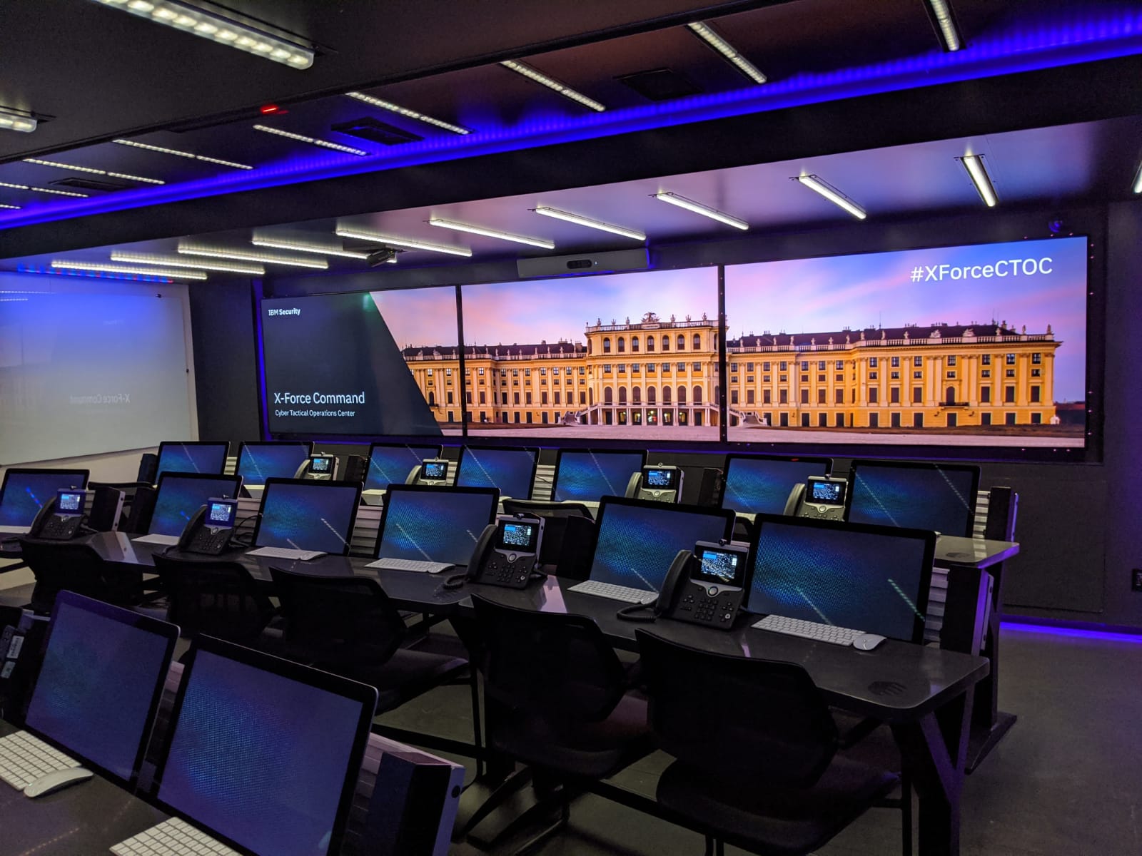 IBM command center with laptops and big screens