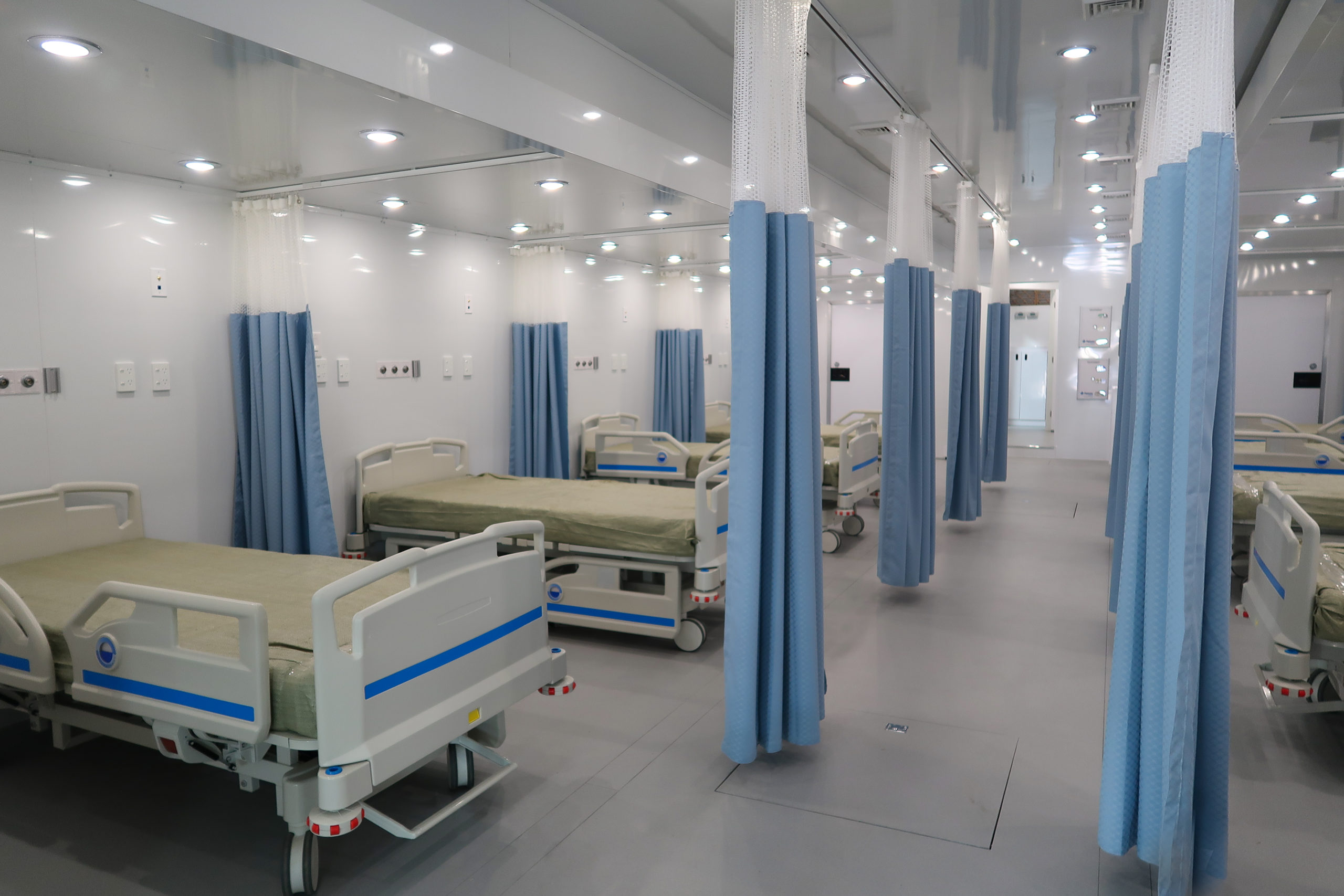 Interior of a mobile medical trailer with beds and curtains